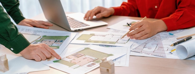 Un retrato de un arquitecto hábil discutiendo con su compañero de trabajo sobre el diseño de la construcción de una casa durante el uso de una computadora portátil Ingenieros profesionales eligen cuidadosamente el plan de la casa Delineación de primer plano