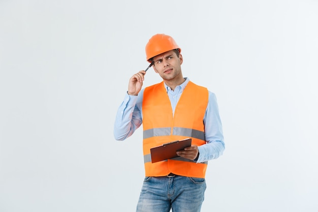 Retrato de arquitecto o ingeniero serio escribiendo o tomando notas en un portapapeles aislado sobre fondo blanco.