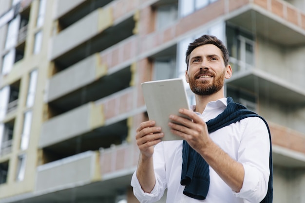 Retrato de arquitecto profesional que trabaja con tableta digital en proyecto de construcción. Concepto de industria de la construcción y tecnología moderna.