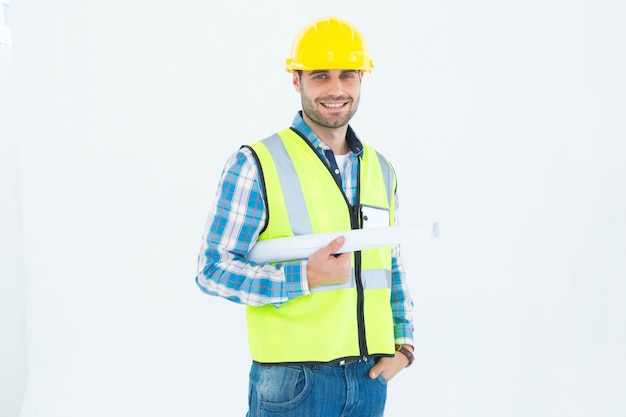 Retrato del arquitecto sonriente que sostiene el modelo contra el fondo blanco