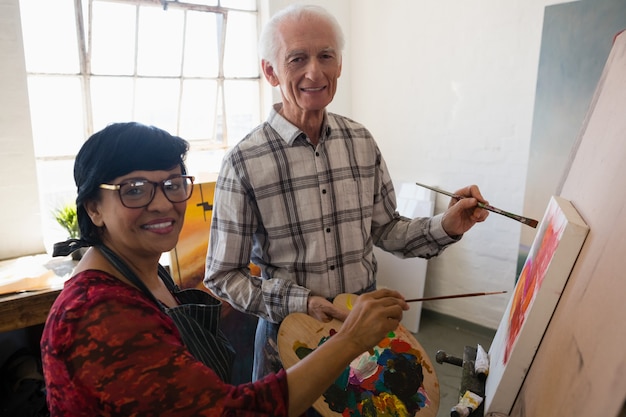 Retrato de artistas mayores pintando sobre lienzo