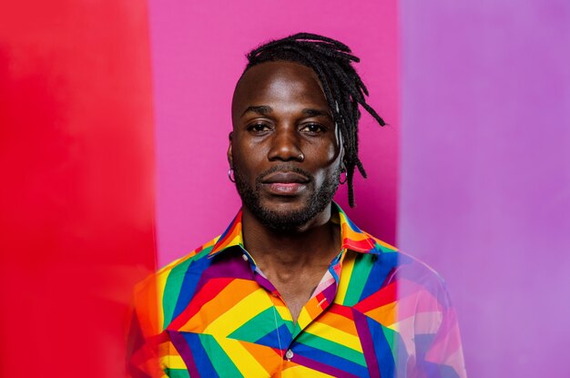 Foto retrato artístico com luzes de gel. homem bonito posando em fundos coloridos