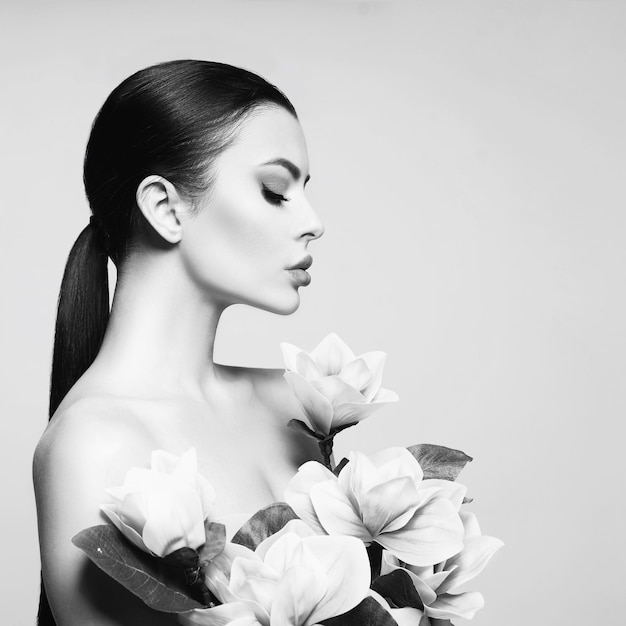 Foto retrato artístico de uma mulher elegante com lindas flores