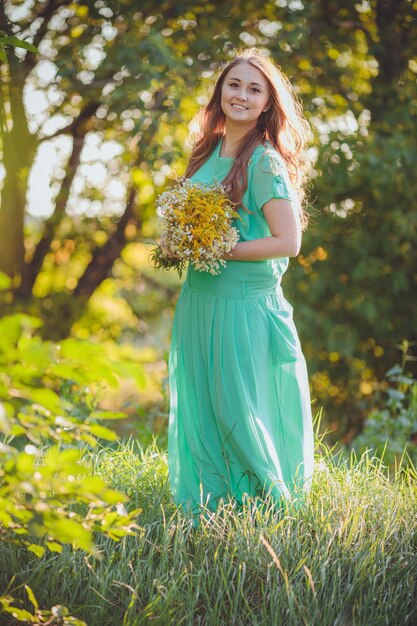 Retrato artístico de una joven morena hermosa en un prado verde