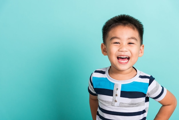 Retrato asiático de la cara feliz del niño que ríe sonríe y mira a la cámara