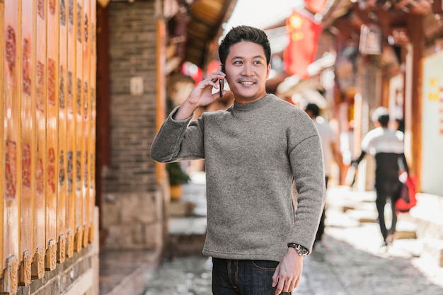 Retrato asiático felicidad hombre usando teléfono móvil inteligente para llamar