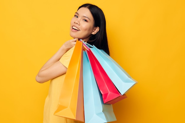 Retrato asiático hermosa mujer joven con paquetes en manos modelo de estudio de compras inalterado