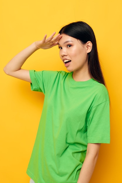 Retrato asiático hermosa mujer joven posando en camiseta verde emociones copyspace studio modelo inalterado