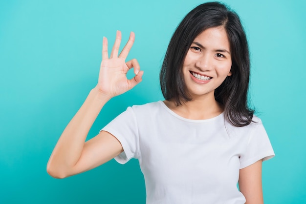 Retrato asiático joven y bella mujer hecha dedo OK símbolo signo