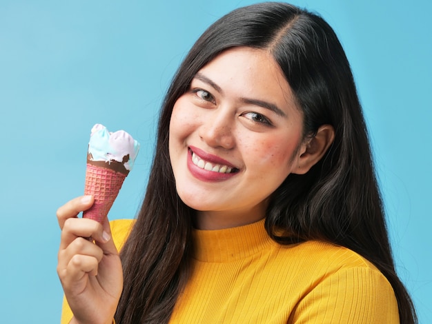 Retrato asiático joven de la mujer en sonrisa azul del fondo y concepto feliz