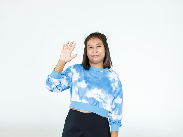 Retrato asiático mulher bonita vestindo camisa casual em pé poses, apontando o anúncio no fundo branco, cópia espaço em branco com um isolado olhar sorridente para a câmera.