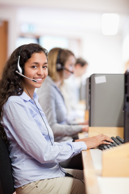 Foto retrato de un asistente sonriente que trabaja con una computadora