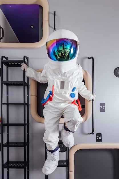 Retrato de astronauta en traje espacial en módulo para dormir de hotel cápsula