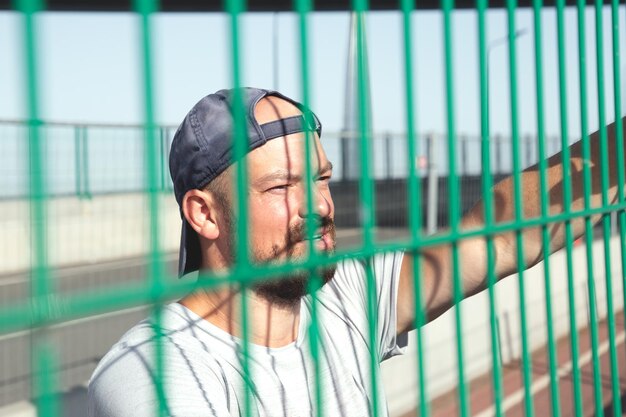 Foto retrato, de, un, atleta, en, un, gorra de béisbol, contra, el, plano de fondo, de, un, cuadrícula