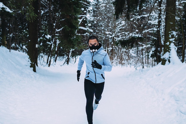 Retrato de un atleta que corre en un campo cubierto de nieve