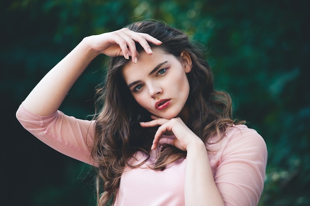 Retrato atmosférico de mujer hermosa joven, cabello largo y maquillaje casual, pared de la naturaleza