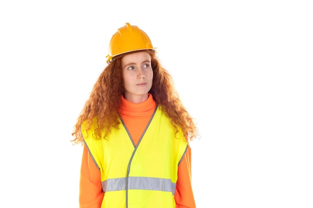 Retrato de una atractiva y alegre pelirroja afortunada con casco y chaleco reflectante