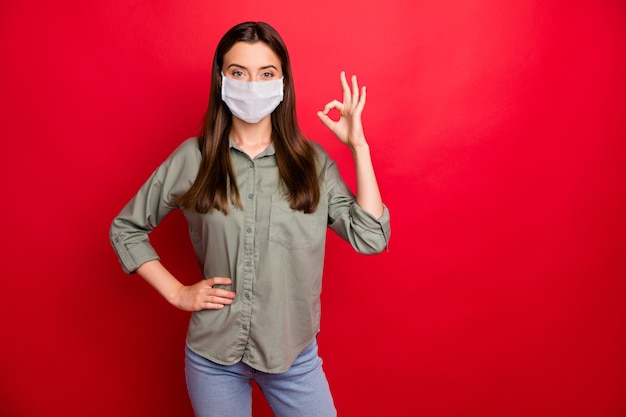 Foto retrato de una atractiva chica sana con máscara de seguridad que muestra la señal de ok detener la enfermedad de la gripe