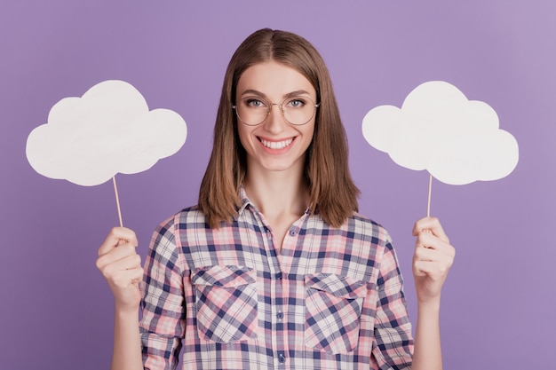 Retrato de atractiva dama encantadora feliz sonrisa positiva mantenga nubes burbuja aislada sobre fondo de color violeta