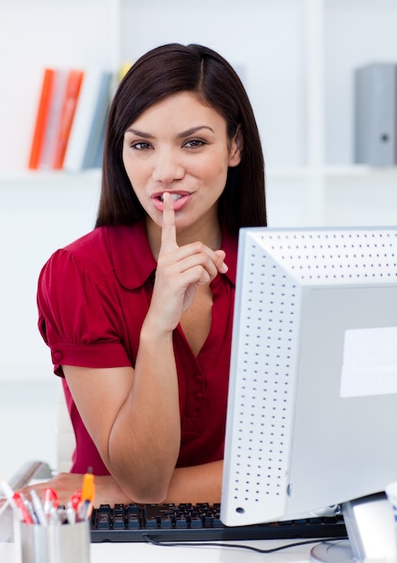 Retrato de una atractiva empresaria pidiendo silencio