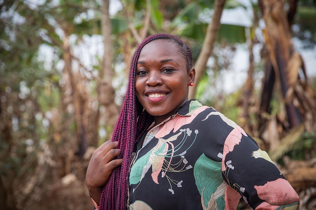 Retrato de una atractiva joven africana sonriendo con trenzas