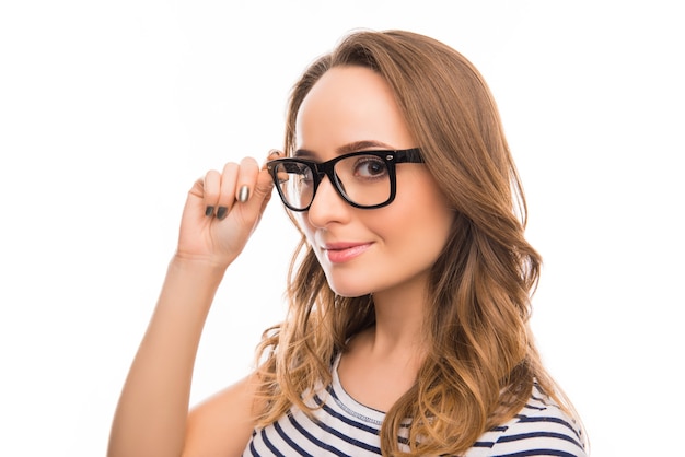 Retrato de atractiva joven inteligente tocando sus gafas