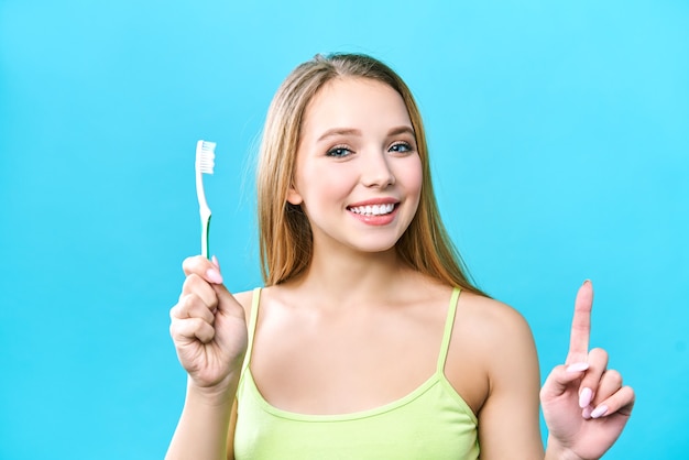 Retrato de atractiva mujer sonriente caucásica cepillarse los dientes