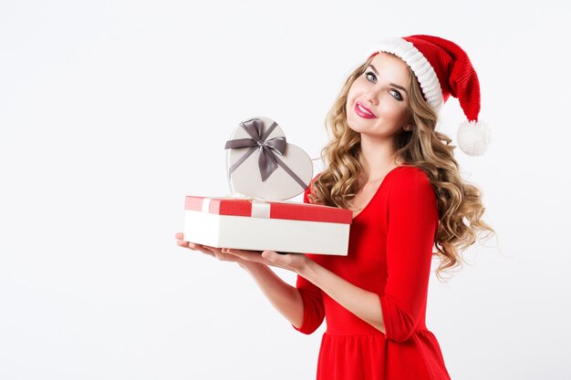 Retrato de atractiva mujer sonriente rubia con sombrero de santa y vestido rojo