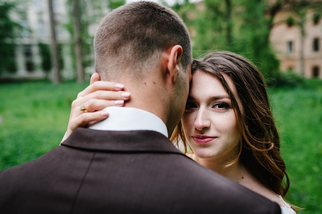 Retrato de una atractiva novia que abraza al novio.