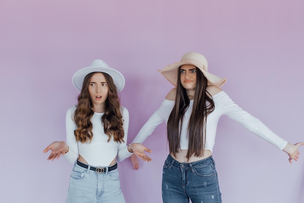 Retrato de atractivas mujeres jóvenes sorprendidas mirando a la cámara sobre un fondo morado