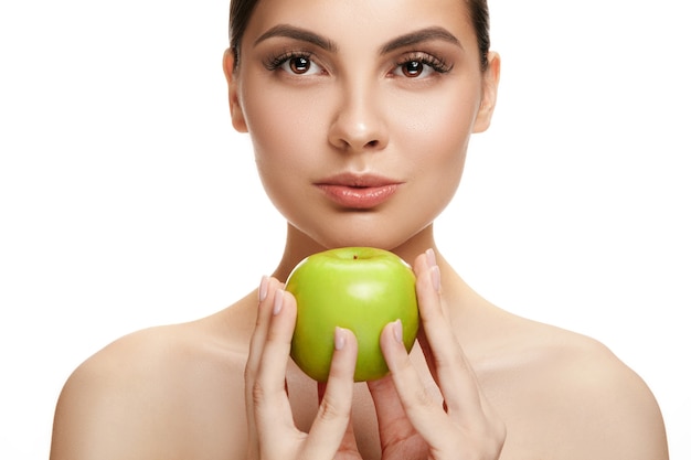 Retrato de atractivo caucásico sonriente sosteniendo una manzana verde mujer aislada en blanco