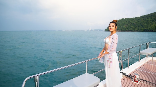 Retrato Atractivo Feliz hermosa mujer asiática sexy vistiendo traje de baño disfrutando en la cubierta del barco velero yate de lujo Viaje de vacaciones vacaciones de verano