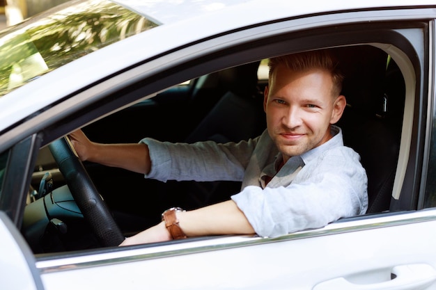 Retrato de un atractivo hombre de 30 años en un auto