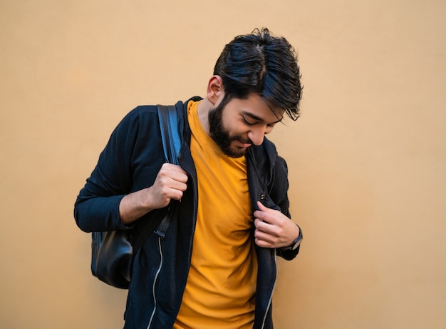 Foto retrato de atractivo joven bered con mochila sobre sus hombros