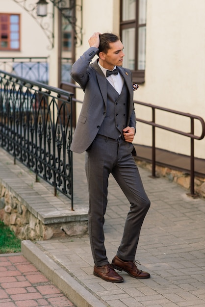 Retrato de un atractivo joven empresario de fondo urbano con traje y corbata.