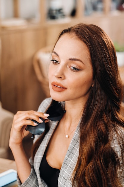 Retrato, de, un, atractivo, mujer joven, que está sentado, en, un, café