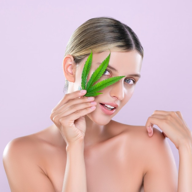 Retrato atraente de mulher bonita segura folha verde como conceito de cuidados com a pele de cannabis