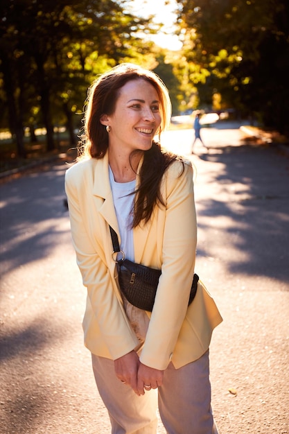 Retrato autêntico da mulher milenar do leste europeu no parque de outono durante o pôr do sol