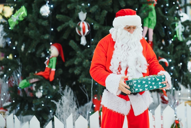 Retrato auténtico Papá Noel con regalos de Navidad en las manos en el centro comercial