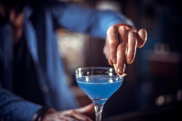 Retrato de barman mezcla un cóctel en bares de copas