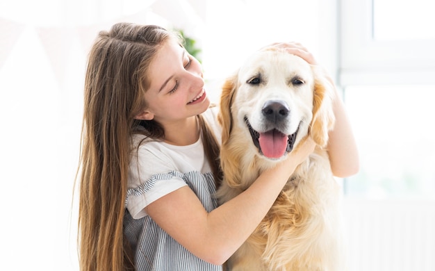 Retrato de bastante adolescente con hermoso perro en el interior