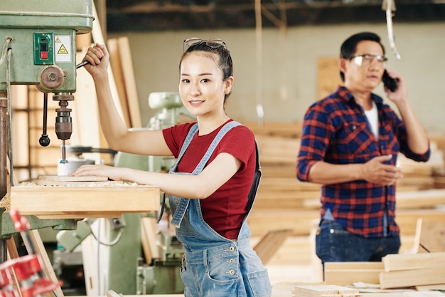 Retrato de bastante joven carpintero trabajando en carpintería y fabricación de muebles