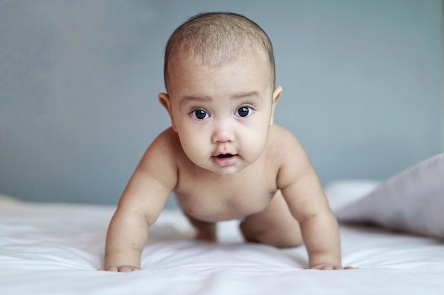 Retrato de un bebé arrastrándose en la cama