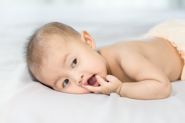 Retrato de bebé en una cama en el dormitorio