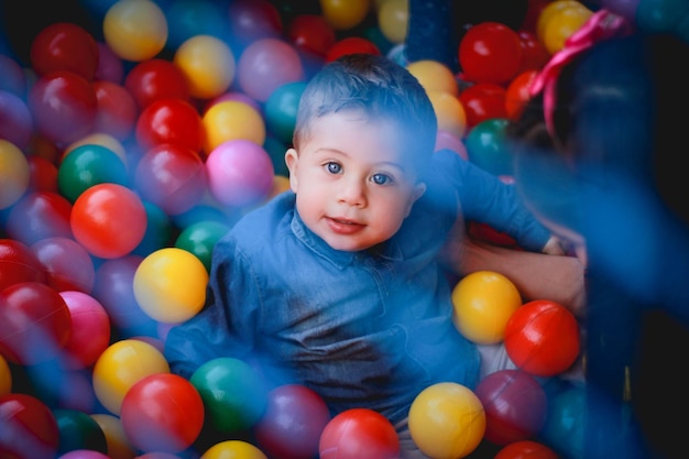 Retrato de un bebé lindo jugando con bolas de colores
