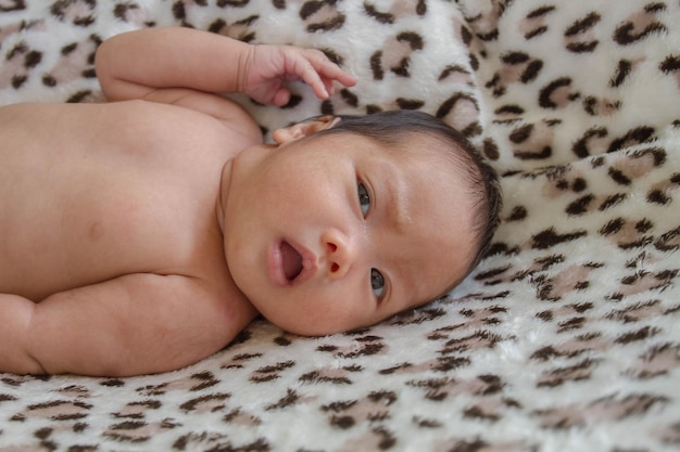 Foto retrato de un bebé lindo tendido en la cama