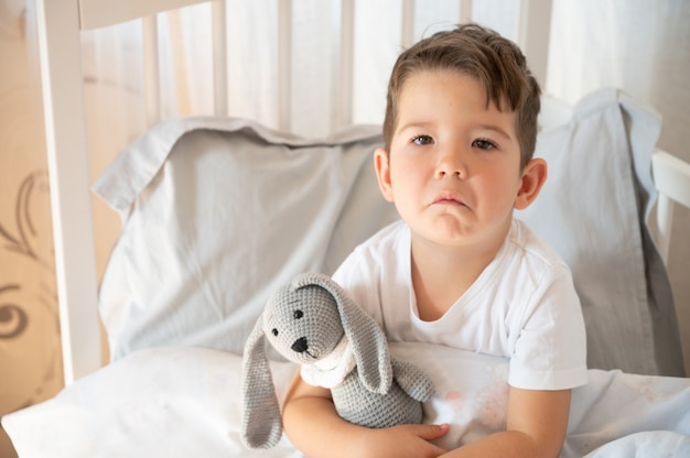 Retrato de bebé molesto en la cuna. Pequeño bebé triste. El niño se niega a dormir. Bebé solitario quédate en la cuna. Soledad. Foto de alta calidad