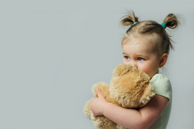 Retrato de bebé niño pequeño con peluche mirando a otro lado