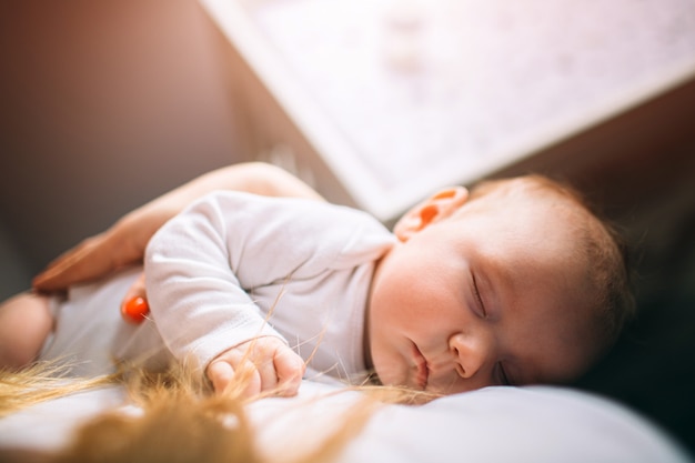 Retrato de un bebé recién nacido. La madre sostiene a un niño en sus brazos. El primer año de vida. Cuidado y salud.