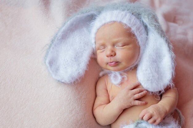 Retrato de un bebé recién nacido en un traje de conejito para dormir